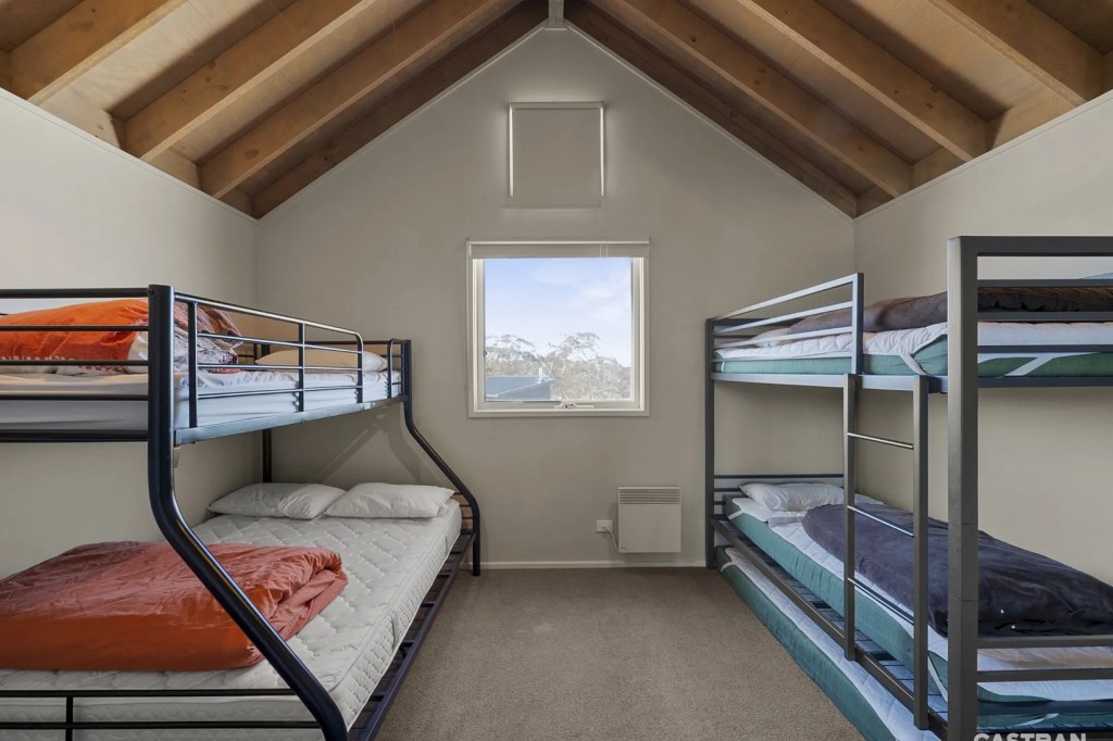 picture of a large bedroom with vaulted ceiling and 2 bunk beds, the left bunk has a double on the bottom